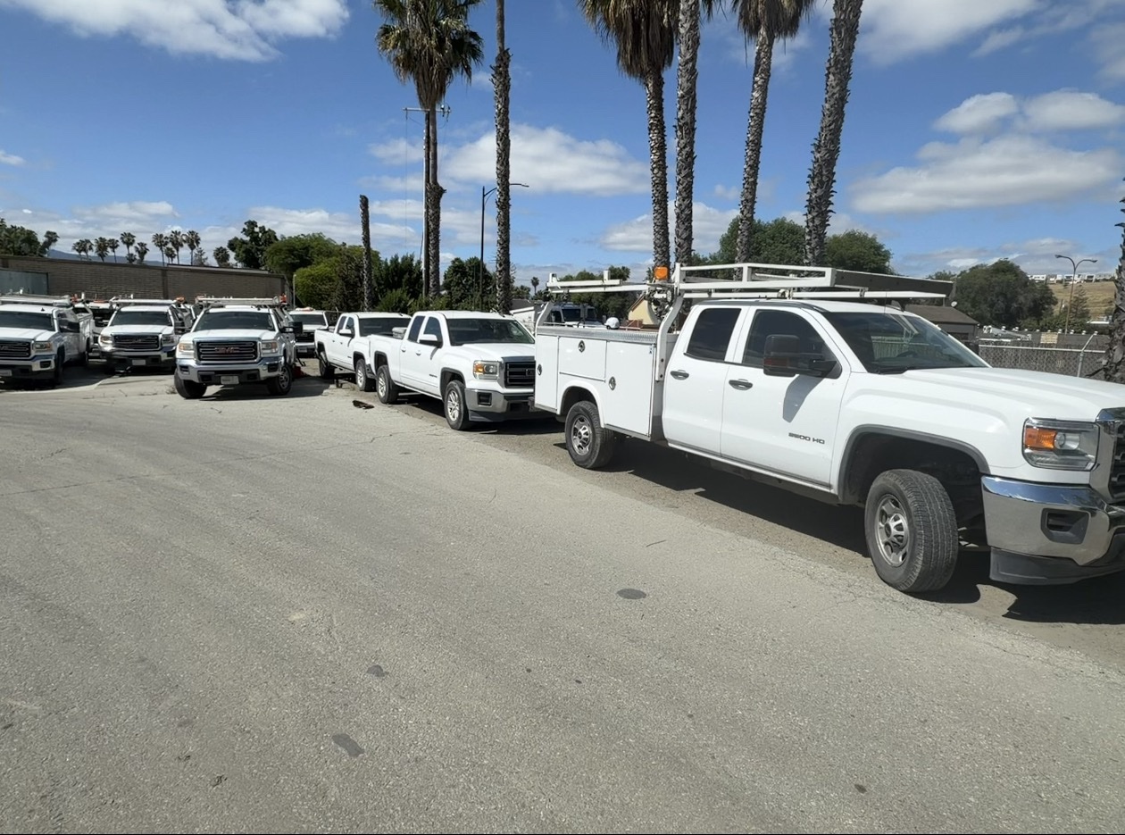 Fleet of white GMC service trucks available for nationwide purchase